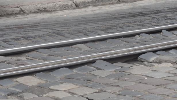 Gleise einer Straßenbahn liegen auf einem Pflasterweg.