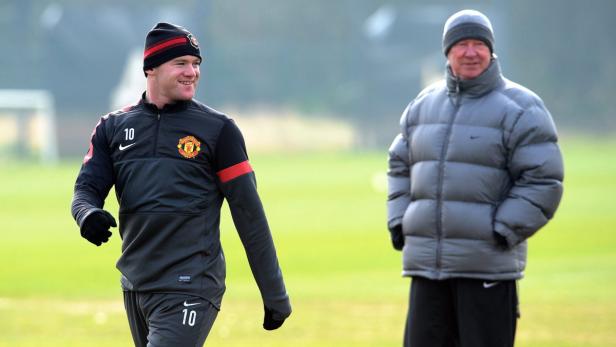 epa03609080 Manchester United manager Alex Ferguson (R) watches striker Wayne Rooney (L) and teammates during the training session at Carrington training facility, Greater Manchester, Britain 04 March 2013. Manchester United will face Real Madrid on March 5th at Old Trafford for the second leg of their encounter in the UEFA Champions League Round of 16. EPA/PETER POWELL