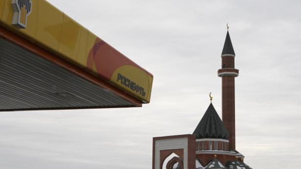 A mosque is seen next to the company logo on a Rosneft petrol station in Moscow December 13, 2012. Rosneft has finalised a deal to buy half of TNK-BP for $28 billion (17 billion pounds), clearing the way for a full takeover that would make the state-controlled Russian oil major the world&#039;s largest listed oil firm by output. REUTERS/Maxim Shemetov (RUSSIA - Tags: BUSINESS ENERGY RELIG ION)