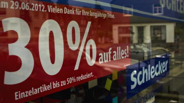 Ein Schaufenster mit der Aufschrift „30% auf alles! Einzelartikel bis zu 50% reduziert“.