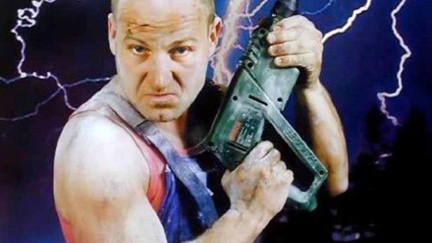 Das Filmplakat zu „Hinterholz 8“ zeigt einen Mann mit Bohrmaschine vor einem Gewitterhimmel.