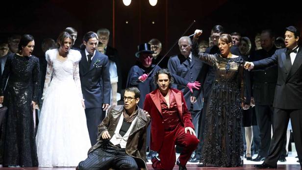 Eine Opernszene mit Sängern in Kostümen auf einer Bühne.