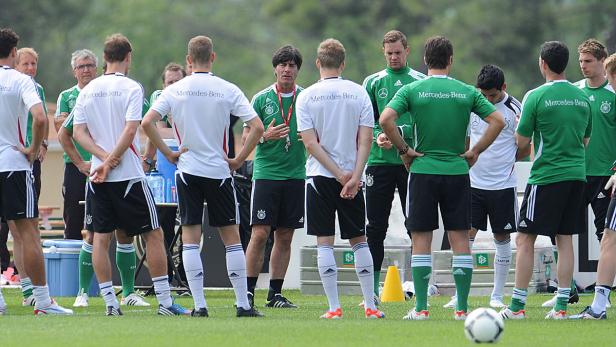 Joachim Löw bespricht sich mit der deutschen Nationalmannschaft auf dem Trainingsplatz.