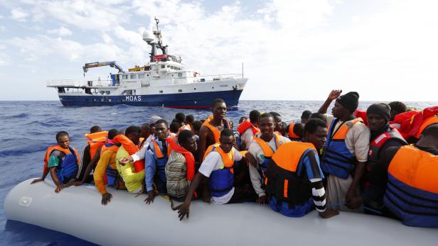 Rettung in letzter Minute: Die Helfer von „Moas“ holen die Flüchtlinge an Bord.