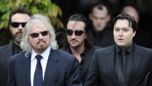 EPAepa03254574 Barry Gibb (L) and Robin-John Gibb (R) walk behind a horse drawn carriage carrying the coffin of former Bee Gee Robin Gibb to the funeral in St Marys church in Thame, Britain, 08 June 2012. Robin Gibb died on 20 May 2012. EPA/FACUNDO ARR Abschied von Robin Gibb