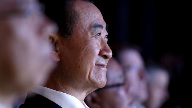 Ein Mann mittleren Alters schaut lächelnd in die Ferne.