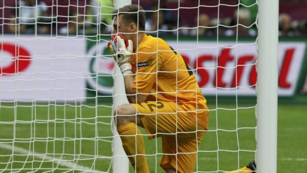 Ein enttäuschter Torwart kniet im Netz seines Tores.