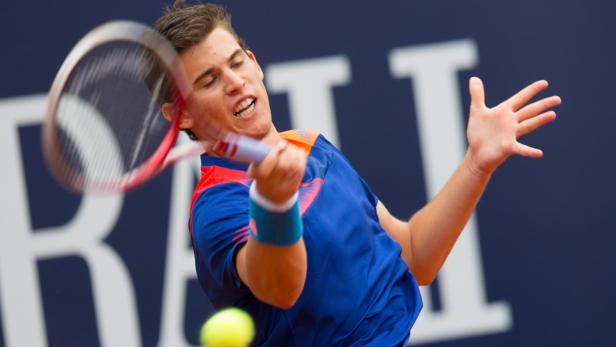Ein Tennisspieler schlägt einen Ball mit seinem Schläger.