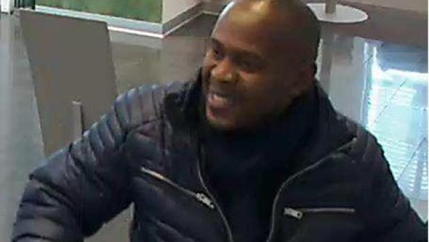 Ein Mann mit dunkler Jacke und dunklem Rollkragenpullover schaut zur Seite und spricht.