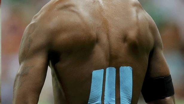 Sportler mit bunten Klebestreifen auf Armen, Beinen, Schultern oder auf dem Rücken. Auch Profis wie Fußballstar Mario Balotelli bei der WM 2014.