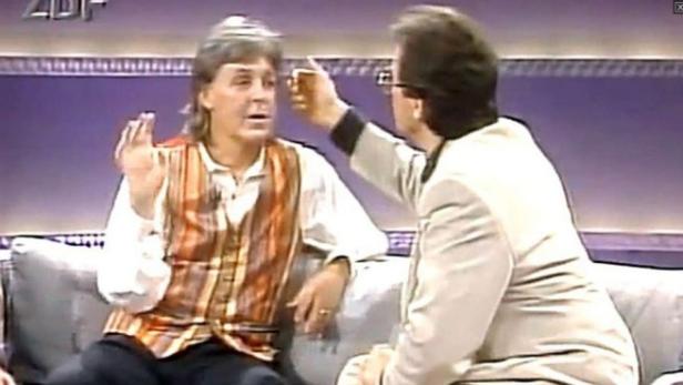 Ein Mann im Gespräch mit einem anderen in einer Fernsehsendung.