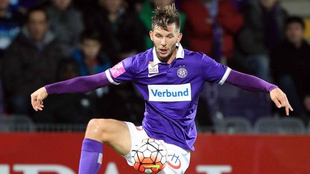 Ein Fußballspieler in lila Trikot balanciert einen Ball auf seinem Knie.