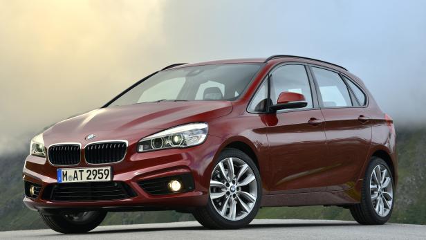 Ein rotbrauner BMW 2er Active Tourer steht auf einer Straße.