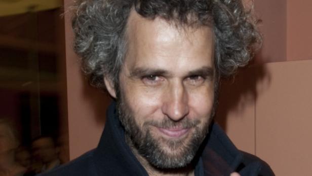 Porträt von Regisseur Michel Gondry mit grauem, lockigem Haar und Bart.