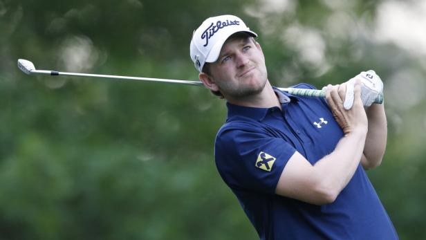 Ein Golfspieler schwingt seinen Schläger auf einem Golfplatz.