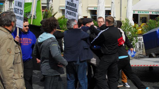 Auf einer Demonstration kommt es zu einer Auseinandersetzung zwischen mehreren Personen.
