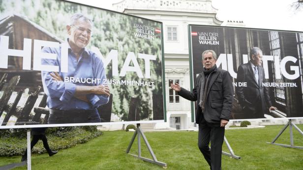 Alexander Van der Bellen vor zwei seiner vier Plakate