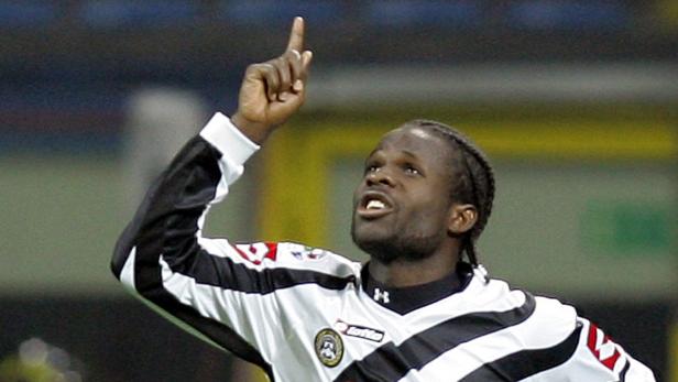 Ein Fußballspieler in einem schwarz-weißen Trikot jubelt mit erhobenem Zeigefinger.