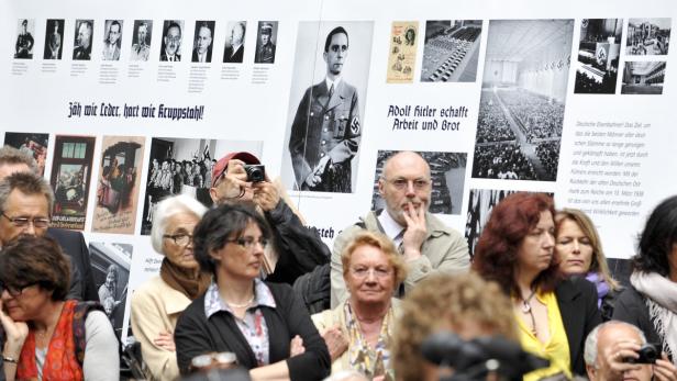 Eine Gruppe von Menschen betrachtet eine Ausstellung über die Zeit des Nationalsozialismus.