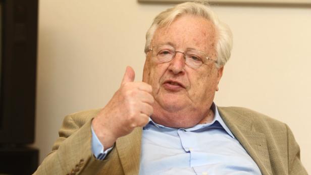 Ein älterer Mann mit Brille und hellem Haar zeigt den Daumen nach oben.