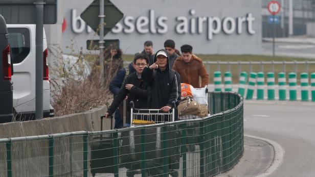 Eine Gruppe von Reisenden mit Gepäckwagen am Brüsseler Flughafen.