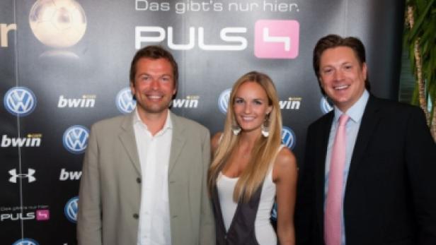 Drei Personen posieren vor einer Wand mit Logos von Puls 4, Volkswagen und Bwin.