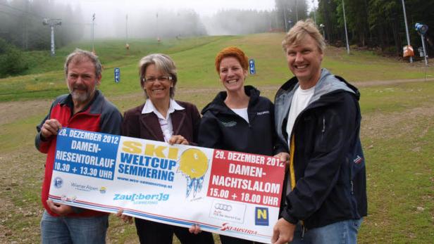 Vier Personen halten ein Schild für den Ski-Weltcup Semmering 2012.