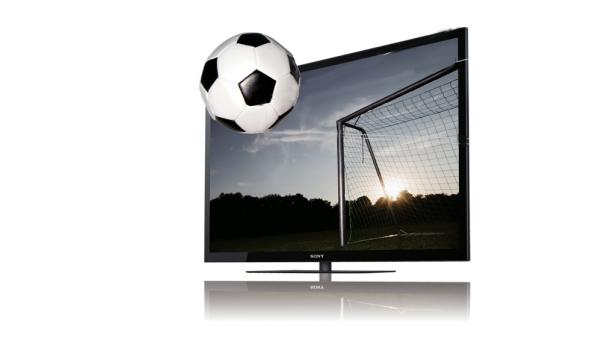 Ein Fußball scheint aus dem Bildschirm eines Sony-Fernsehers zu kommen, der ein Fußballfeld zeigt.