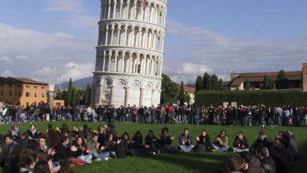 Eine Menschenmenge versammelt sich vor dem Schiefen Turm von Pisa.