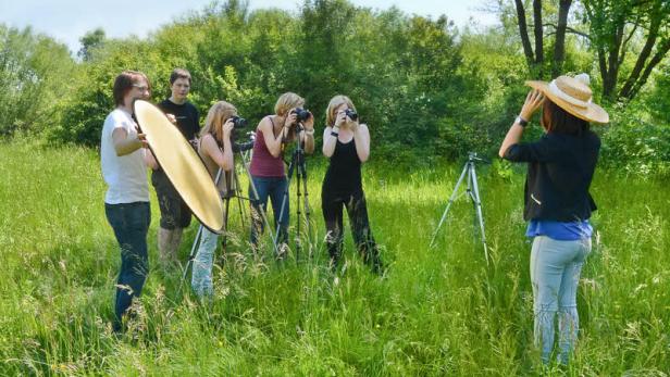 Eine Gruppe von Fotografen bei einem Fotoshooting im Freien.
