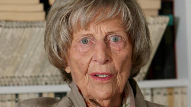Nahaufnahme einer älteren Frau mit grauen Haaren und hellen Augen.