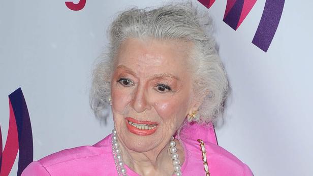 June Squibb trägt ein pinkfarbenes Oberteil und eine Perlenkette.