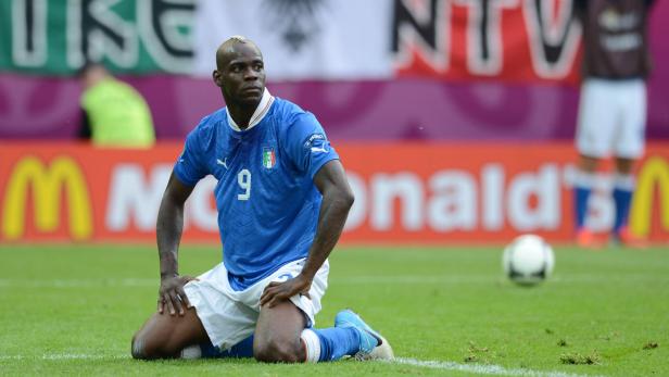 Mario Balotelli kniet während eines Fußballspiels auf dem Rasen.