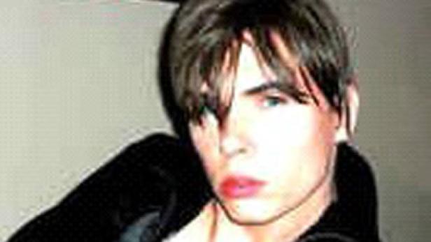 Ein Porträt eines jungen Mannes mit dunklen Haaren und hellen Augen.