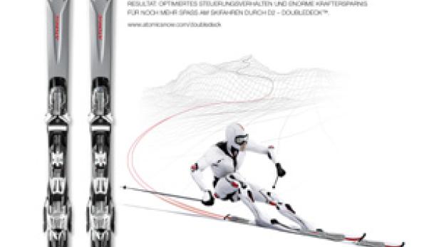 Ein Paar Atomic D2 Ski und ein Skifahrer in weißer Montur.