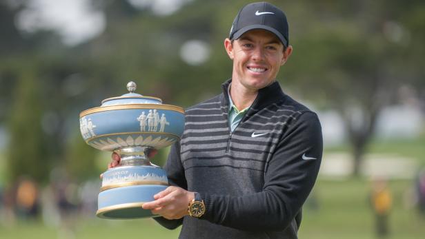 Rory McIlroy hält den Siegerpokal in die Kamera.