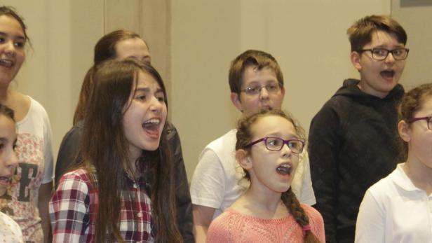 Eine Gruppe von Kindern singt in einem Chor.