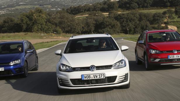 Drei VW Golf Modelle in Blau, Weiß und Rot fahren auf einer kurvigen Straße.