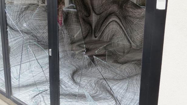 Eine zerbrochene Glasscheibe mit einem abstrakten Muster im Hintergrund.