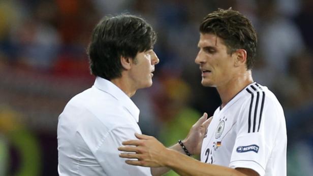 Joachim Löw spricht mit einem Spieler der deutschen Nationalmannschaft.