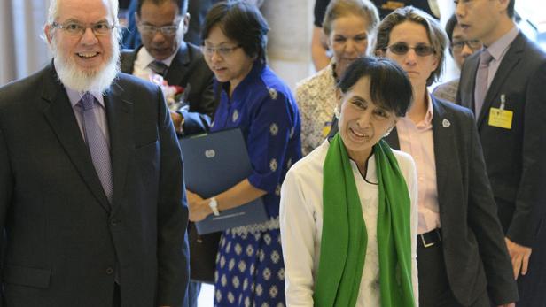 Aung San Suu Kyi umgeben von anderen Personen.