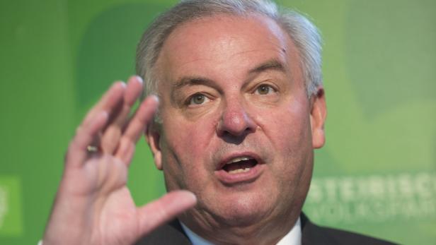 Ein Mann gestikuliert vor einem grünen Hintergrund.