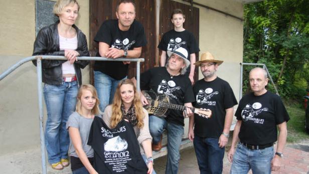 Eine Gruppe von Personen posiert mit T-Shirts der Band Stadlblues Chill Out.