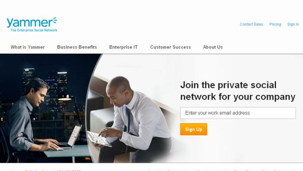 Zwei Männer arbeiten an Laptops und Tablets vor einem unscharfen Hintergrund.