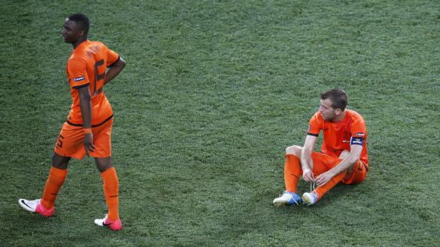 Zwei niederländische Fußballspieler in oranger Spielkleidung auf dem Rasen.