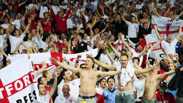 Eine jubelnde Menge von Fußballfans schwenkt England-Flaggen.