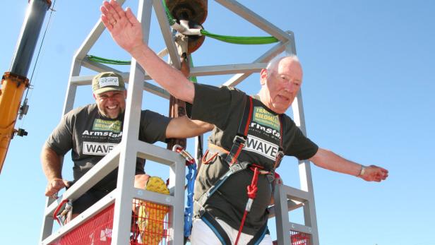 Zwei Männer stehen in einem Gerüst, bereit für einen Bungeesprung.