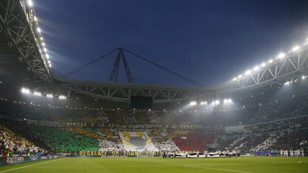 Blick in ein Fußballstadion mit Fans und einem großen Banner während eines UEFA Champions League Spiels.