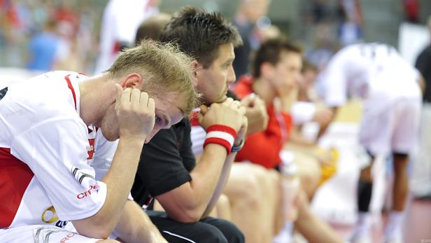 Enttäuschte Handballspieler sitzen auf der Bank.
