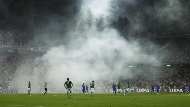 Während eines Fußballspiels steigt Rauch vor den Zuschauern auf.